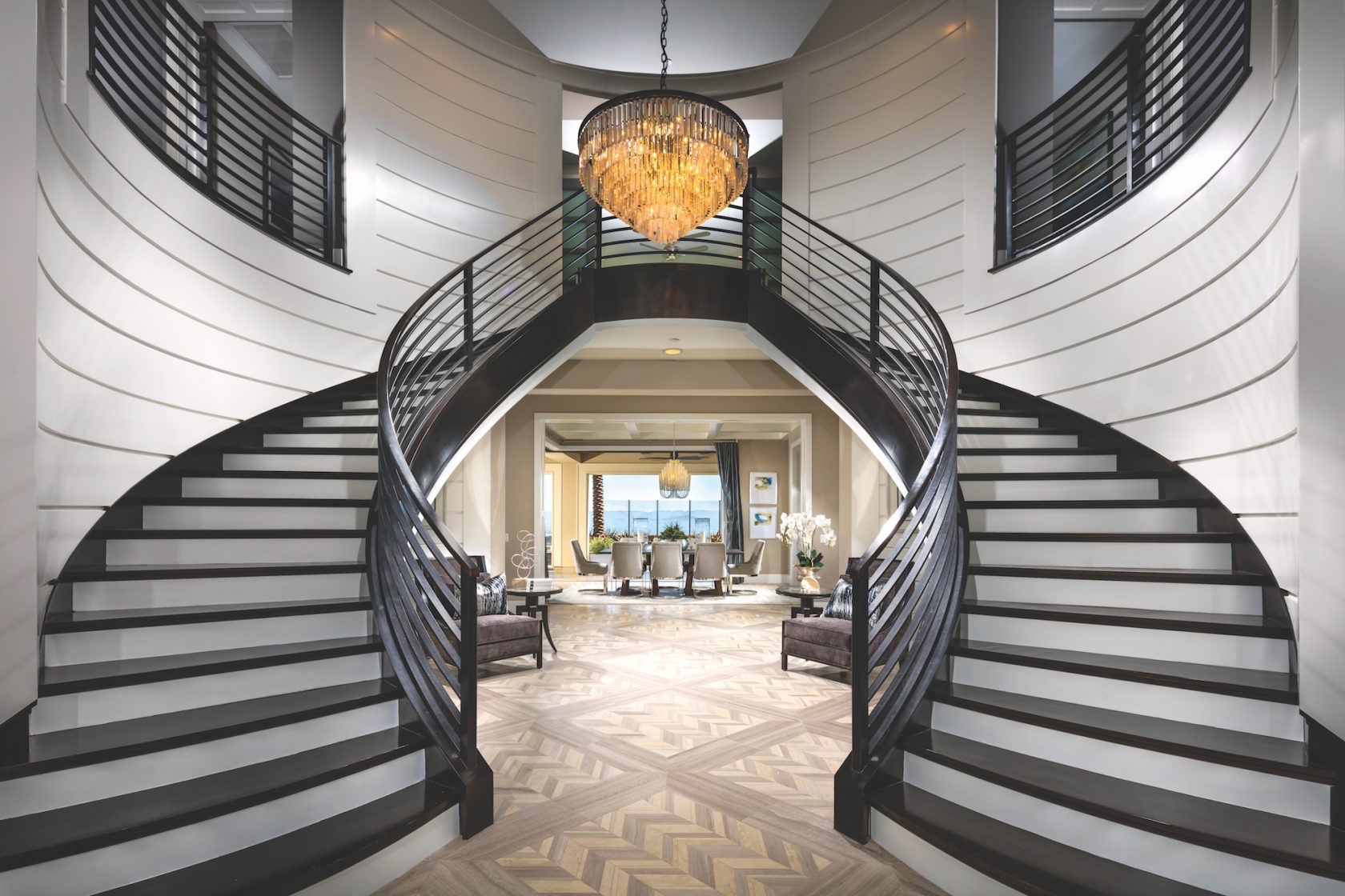 Dramatic curved dual staircase with horizontal railings